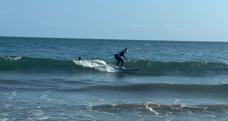 Intermediate surfer girl on a surfboard at Berawa Beach, Bali